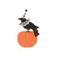Vintage inspired paper party napkins featuring a crow with a decorative collar, tall cone party hat and is perched on an orange pumpkin with gold foil stripe details. High quality die-cut party napkins