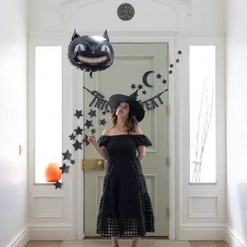 Girl in costume holding the vintage black cat gloss black mylar balloon.