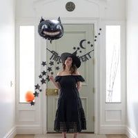 Girl in costume holding the vintage black cat gloss black mylar balloon.