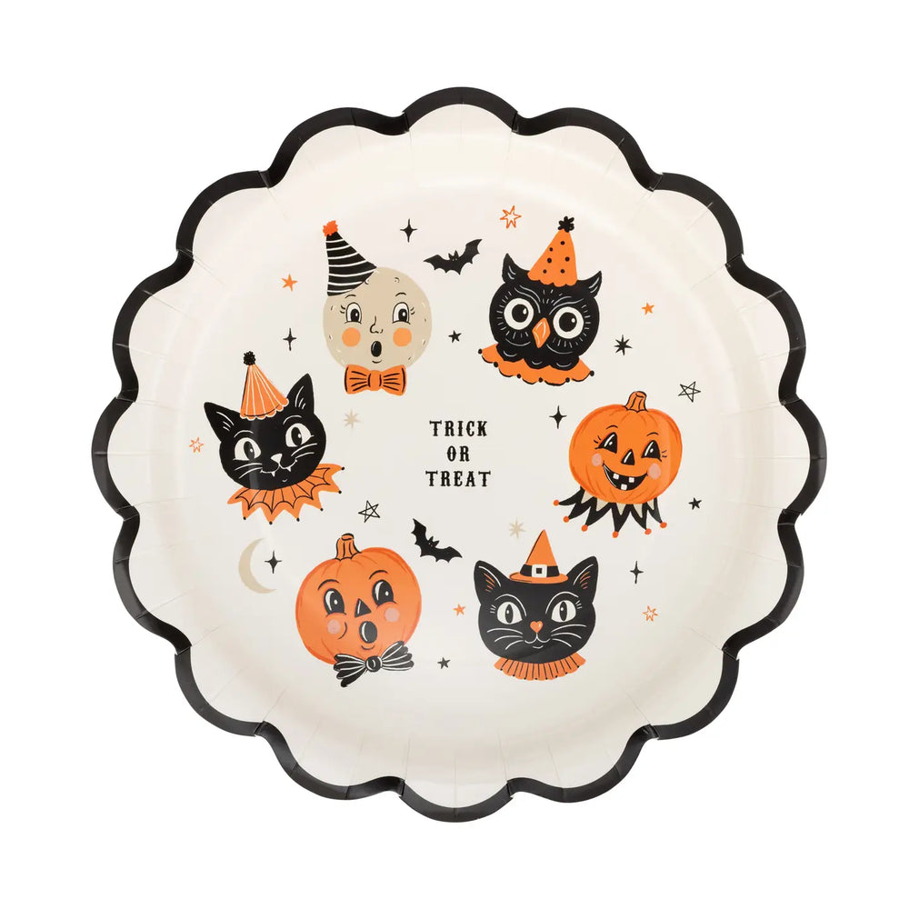 Round cream plate with printed graphics including two Jack-O Lanterns, two cats, owl, moon, flying bats and stars with a black scalloped edge and “ trick or treat “ written in center of plate.

