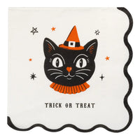 A square cream color paper napkin with a scalloped black border, featuring a vintage inspired black cat wearing an orange witch hat and orange ruffled collar, with small orange and black stars and the words 'TRICK OR TREAT' printed below.