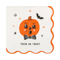 A square cream color paper napkin with scalloped orange edges, featuring a cute cartoon jack-o'-lantern face with a black bow tie, surrounded by small orange stars, a black bat, and the words 'TRICK OR TREAT' at the bottom.