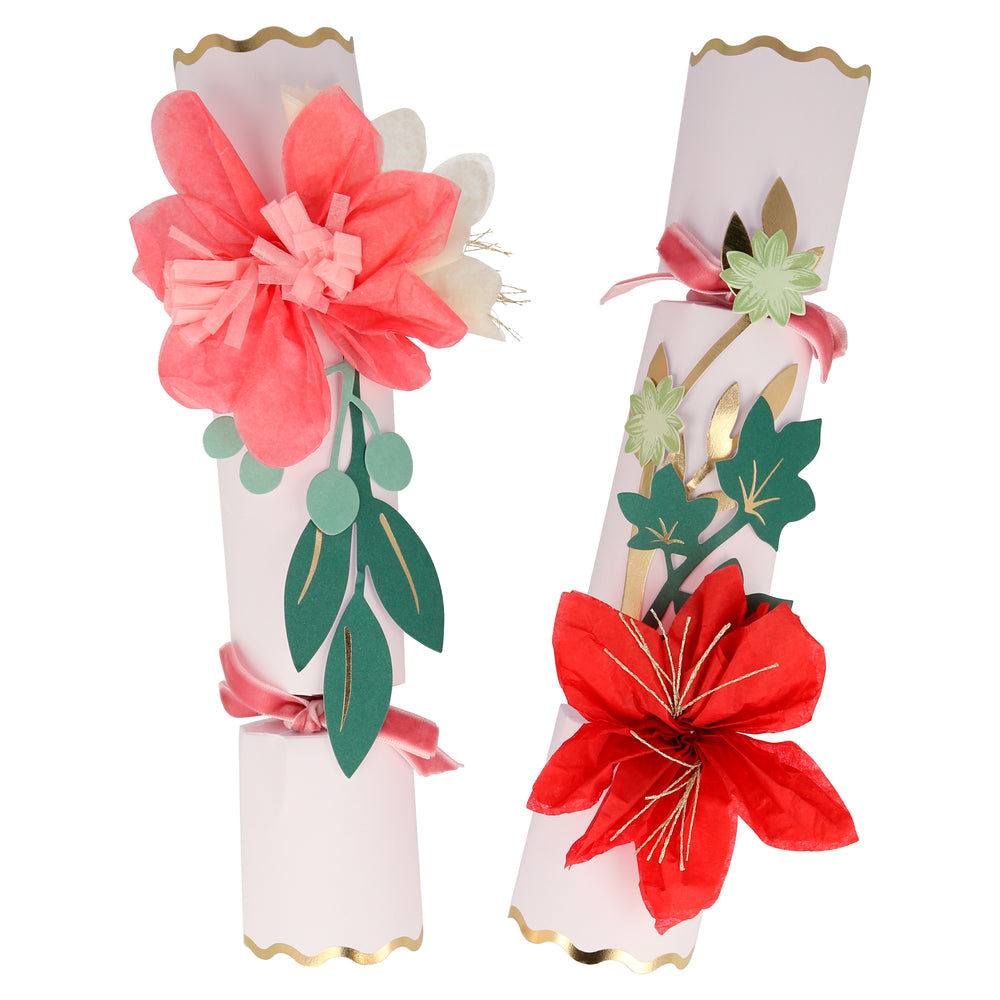 These fancy crackers are floral and festive. Featuring tissue paper flower designs in pink, red, and yellow with gold metallic thread centers, and gold foil bordered scalloped edges and details. Pink velvet ribbons are tied on the crackers for a luxurious touch. Each cracker contains a joke, gold paper hat and a wooden brooch with gold foil detail. The crackers are presented in a brown kraft box Pack of 6 in 2 designs Product dimensions: 2 by 10.75 by 2 inches.