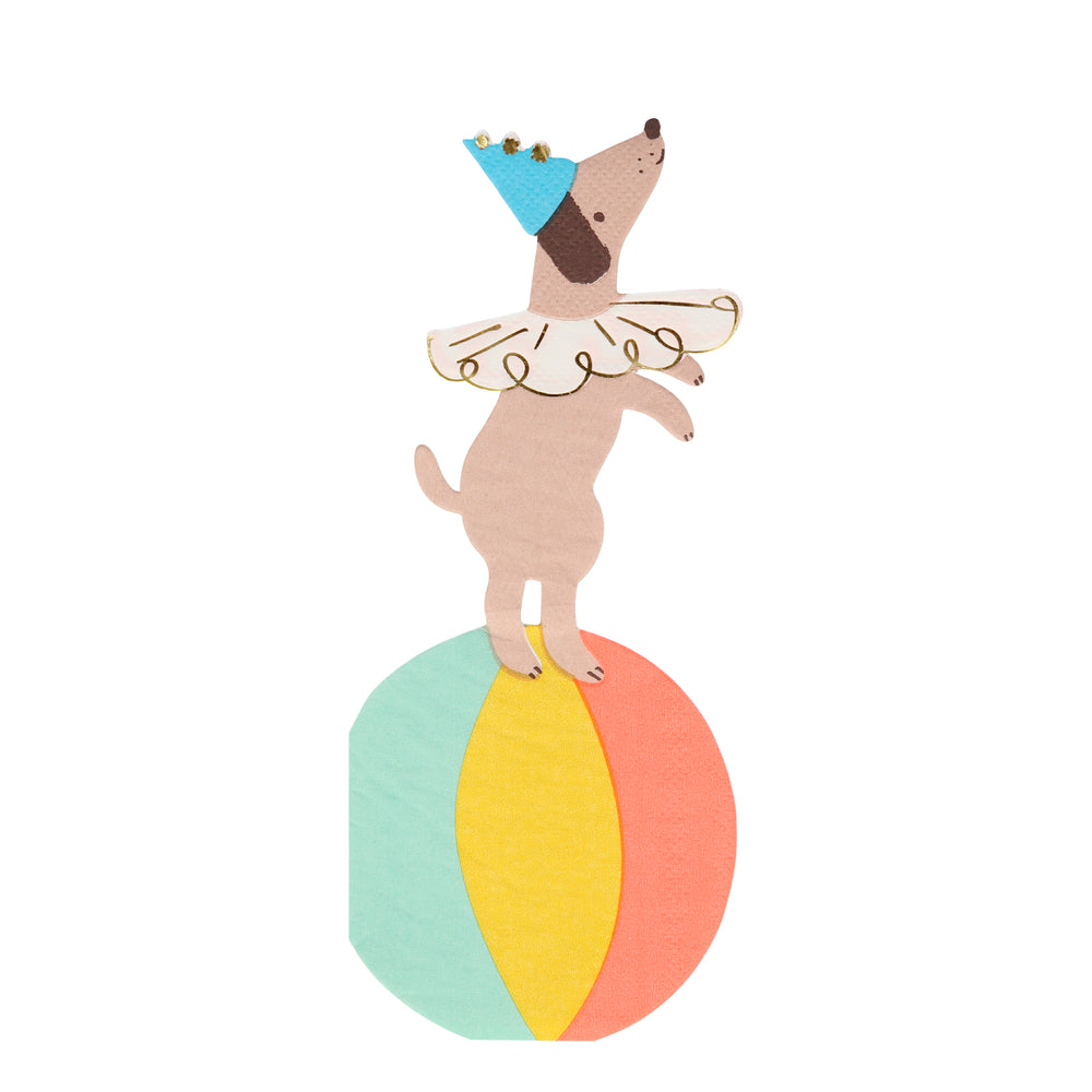 die-cut paper napkins in the shape of a circus dog performer wearing a ruffled collar and cone hat with shiny gold print pom poms and on a colorful ball  