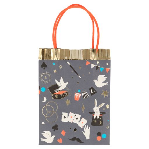 paper party favor bags with a classic magic themed print including playing cards, doves, magic wand, rabbit popping out of a top hat and lots of shiny gold stars and gold highlights. each bag is trimmed with shiny gold fringe and a neon orange twisted paper handle